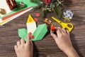 Instruction step 12. Christmas greeting card gift origami candle on wooden table. Childrens art project, handmade, crafts for kids