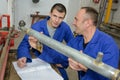 Instructor and apprentice looking at pipe