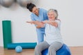 Instructor assisting senior woman in exercising Royalty Free Stock Photo