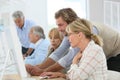 Instructor assisting seniors in informatics class Royalty Free Stock Photo