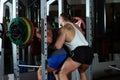 Instructor assists crunching with weight