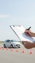 Instructor checking driving license test checklist with car Royalty Free Stock Photo