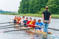 Instructor coach teaching a tourists how the eight rowing boat works in the waters of Galve lake. Eight is a rowing boat used in