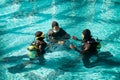 Instructor and divers in aqualungs, dive course Royalty Free Stock Photo