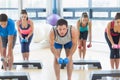 Instructor with fitness class performing step aerobics exercise with dumbbells Royalty Free Stock Photo