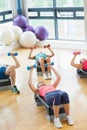 Instructor with fitness class performing step aerobics exercise with dumbbells Royalty Free Stock Photo