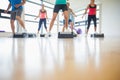 Instructor with fitness class performing step aerobics exercise Royalty Free Stock Photo