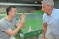 Instructor giving advice to senior man by indoor climbing wall