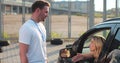 Instructor giving a five to a woman driver sitting in the car while learning to drive on the training ground. Driver