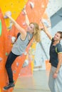 Instructor guiding woman on rock climbing wall at gym Royalty Free Stock Photo