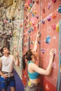 Instructor guiding woman on rock climbing wall Royalty Free Stock Photo