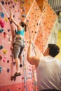 Instructor guiding woman on rock climbing wall Royalty Free Stock Photo