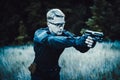 Instructor with gun in forest leads aiming and posing on camera Royalty Free Stock Photo