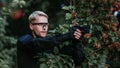 Instructor with gun in forest leads aiming and posing on camera Royalty Free Stock Photo