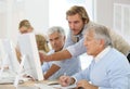 Instructor helping seniors in informatics class Royalty Free Stock Photo
