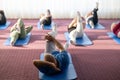 Instructor leading a diverse group of people during a fitness training session with stretching exercises on mats in a Royalty Free Stock Photo