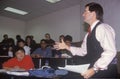 Instructor lecturing to and adult business class