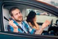 Instructor in misunderstanding, sitting in the passenger seat in a car next to woman who did not pass driving test Royalty Free Stock Photo