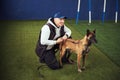 Instructor seated on the synthetic turf next to a dog