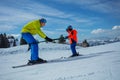 Instructor in skiing school glide backwards teach child to ski