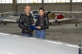 Instructor and Student Pilot Check an Aircraft for Safety in a Hangar