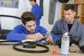 Instructor with student in repairshop changing motor oil