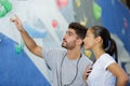 Instructor talking through challenge on indoor climbing wall Royalty Free Stock Photo