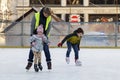 The instructor teaches children to skate.