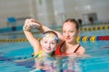 Instructor teaches the girl swimming in a pool