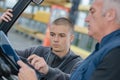 Instructor teaching apprentice how to drive heavy construction vehicle Royalty Free Stock Photo