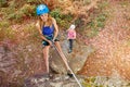 Instructor teaching teenager to abseil outdoors