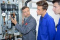 Instructor and trainees looking at pressurised machine Royalty Free Stock Photo