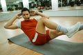 instructor uses a wireless microphone while doing bicycle crunches Royalty Free Stock Photo