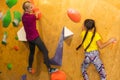 Instructors helping children climb wall in gym