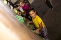 Instructors helping children climb wall in gym