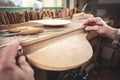 Instrument maker working on a wooden piece of a mandolin