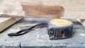 Instrument measuring tape under a layer of dust on a table in a workshop