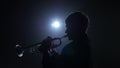 Instrumentalist plays on a trumpet fast melody. Studio in smoke