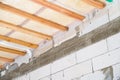 Insulated ceiling of a private house with a wooden crate. The roof is insulated with glass wool and sheathed with a vapor barrier