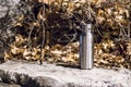 An insulated stainless steel bottle at the forest in the night