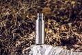 An insulated stainless steel bottle at the forest in the night