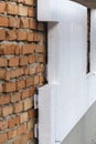 Insulation of a red brick wall with polystyrene white
