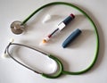 Insulin pen for diabetics with a green stethoscope around Royalty Free Stock Photo