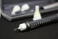 Insulin pen with needles. Selective focus close up on black background. Medical devices are used for self-use in the Royalty Free Stock Photo
