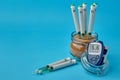 Insulin syringe pens in a jar with brown sugar and a glucometer on a blue background Royalty Free Stock Photo