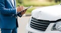 Insurance adjuster inspecting a damaged white car after an accident Royalty Free Stock Photo