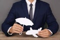 Insurance agent covering paper plane with umbrella cutout at table, closeup. Royalty Free Stock Photo