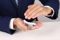 Insurance agent covering toy plane at table, closeup. Royalty Free Stock Photo