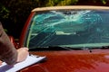 Insurance agent estimates the cost of damaged car after clash with a deer