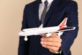 Insurance agent holding toy plane on color background, closeup. Royalty Free Stock Photo